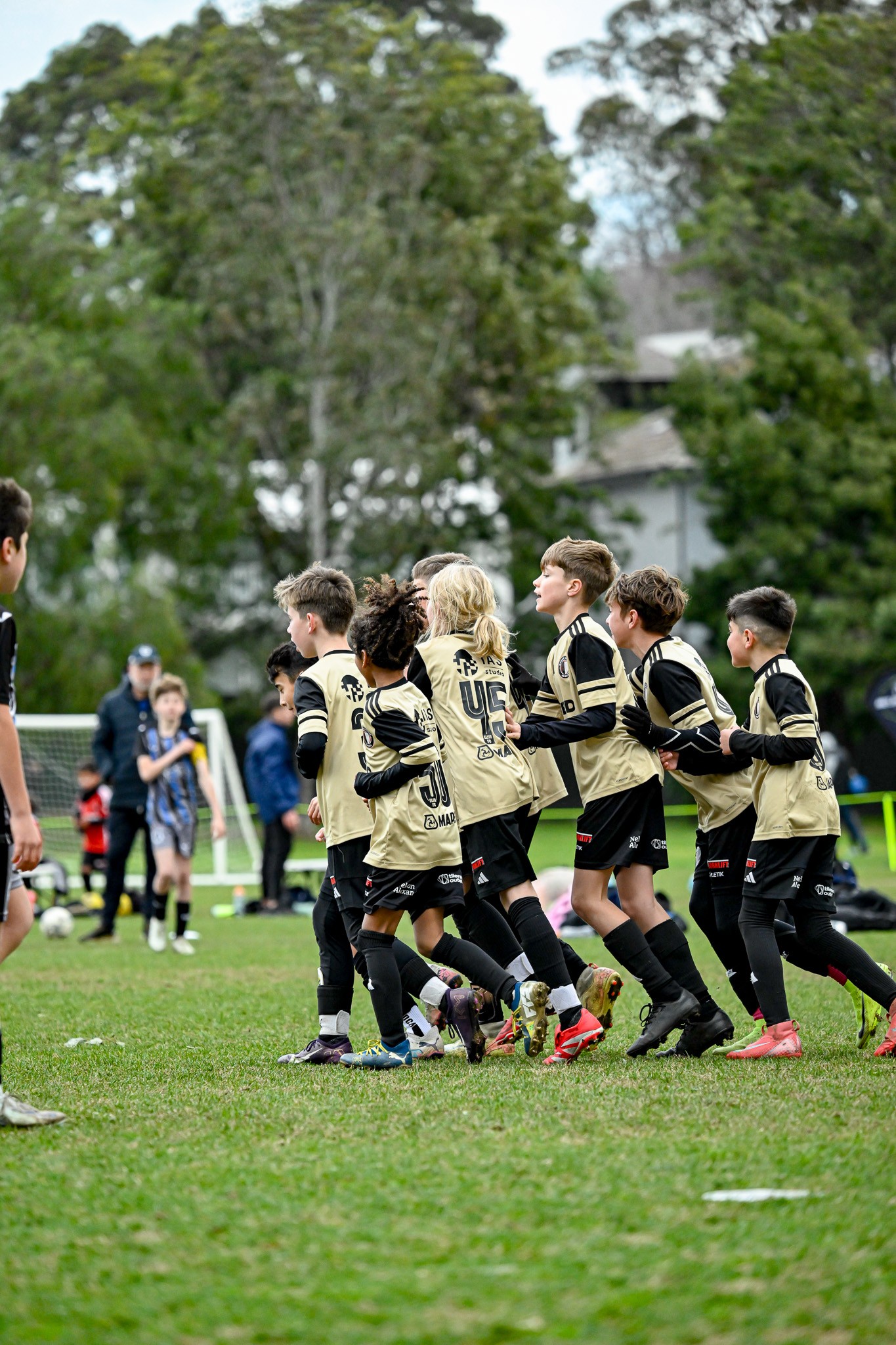 Photo of two women and a man talking in the corner of a room with modern furniture.